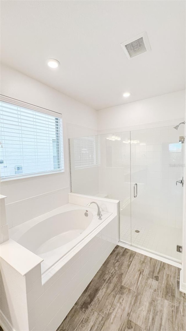 bathroom featuring separate shower and tub and hardwood / wood-style flooring