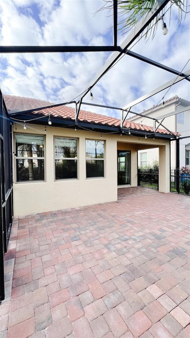 rear view of house featuring a lanai and a patio