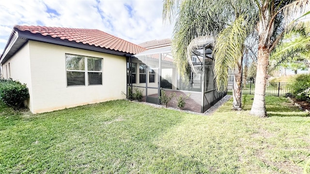 rear view of house featuring a lanai and a yard