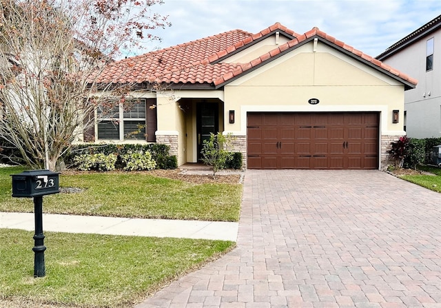 mediterranean / spanish home featuring a front lawn and a garage