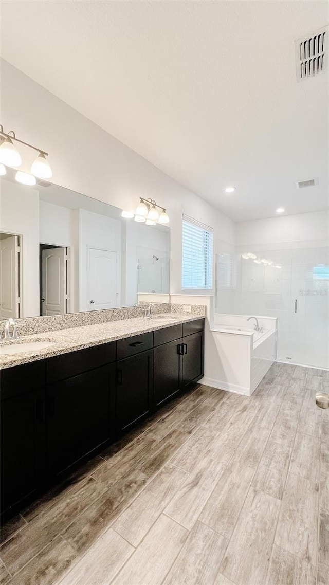 bathroom with vanity and shower with separate bathtub