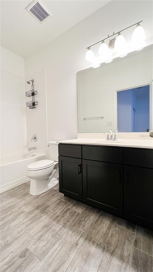 full bathroom featuring toilet, vanity, and tiled shower / bath combo