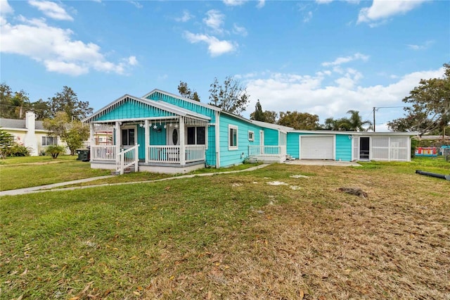 view of front of property featuring driveway, covered porch, an attached garage, and a front lawn