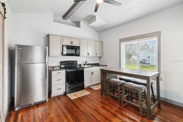 kitchen with vaulted ceiling with beams, dark wood finished floors, a barn door, a sink, and black appliances