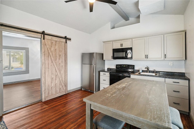 kitchen featuring a barn door, dark wood finished floors, dark countertops, black appliances, and a sink