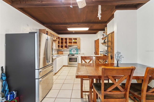 kitchen featuring light tile patterned floors, stainless steel appliances, glass insert cabinets, wood ceiling, and white cabinetry