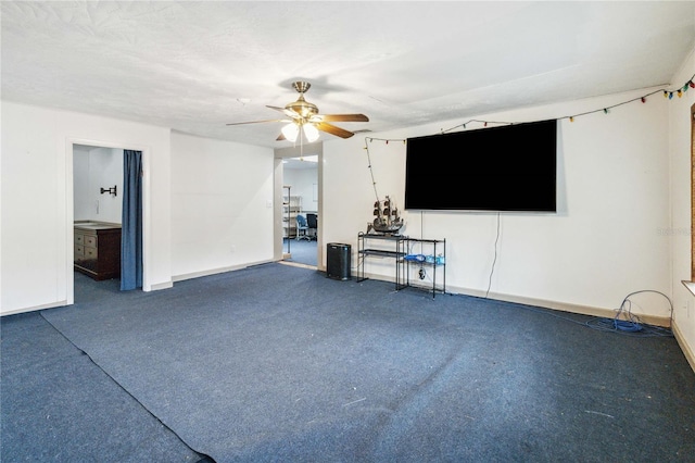 unfurnished living room featuring a ceiling fan, a textured ceiling, and baseboards