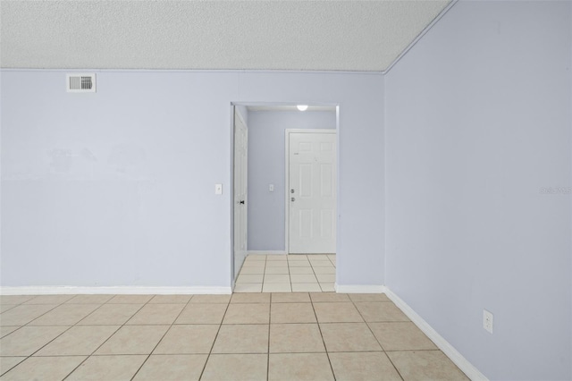 empty room with light tile patterned floors and a textured ceiling