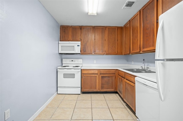 kitchen featuring white appliances, sink, and light tile patterned floors