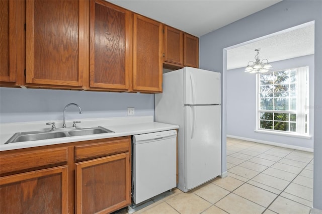 kitchen featuring white appliances, an inviting chandelier, sink, decorative light fixtures, and light tile patterned flooring