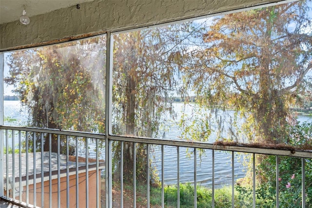 unfurnished sunroom featuring a water view