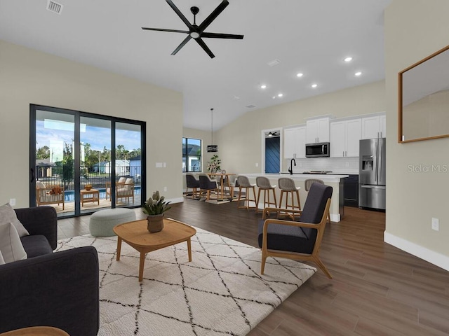 living room featuring ceiling fan, lofted ceiling, wood-type flooring, and sink