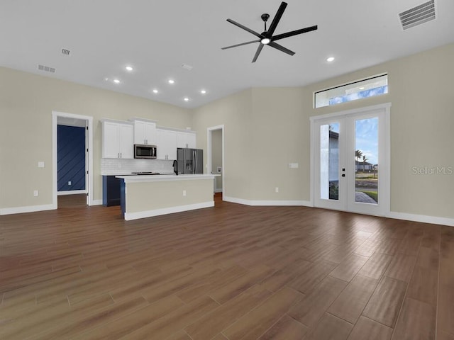 unfurnished living room featuring french doors, dark hardwood / wood-style floors, and ceiling fan