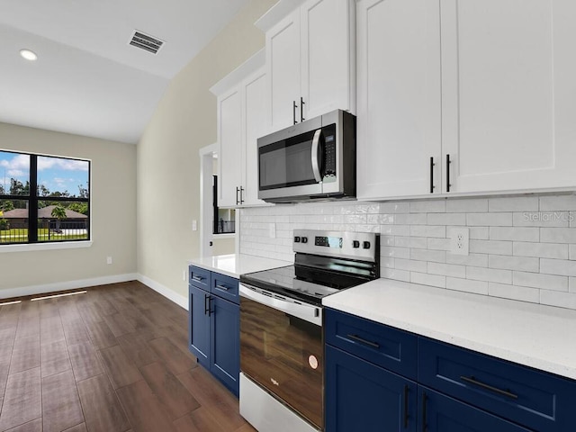 kitchen with lofted ceiling, white cabinetry, blue cabinets, stainless steel appliances, and decorative backsplash