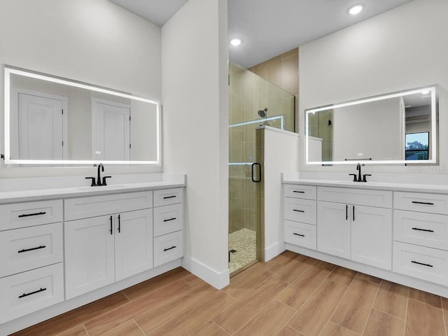 bathroom featuring a shower with shower door and vanity