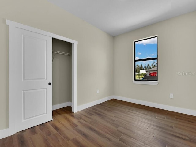 unfurnished bedroom with hardwood / wood-style floors and a closet