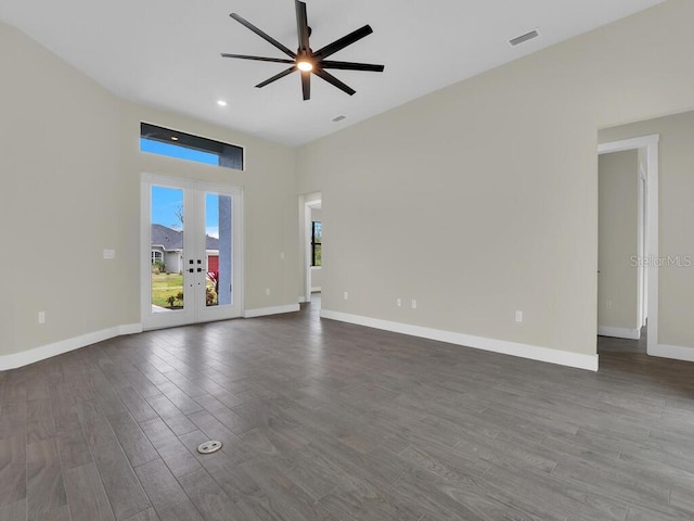 unfurnished room with dark wood-style floors, baseboards, visible vents, ceiling fan, and french doors