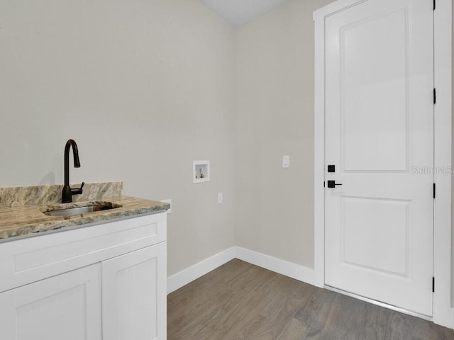 laundry room with a sink, baseboards, hookup for a washing machine, and light wood finished floors