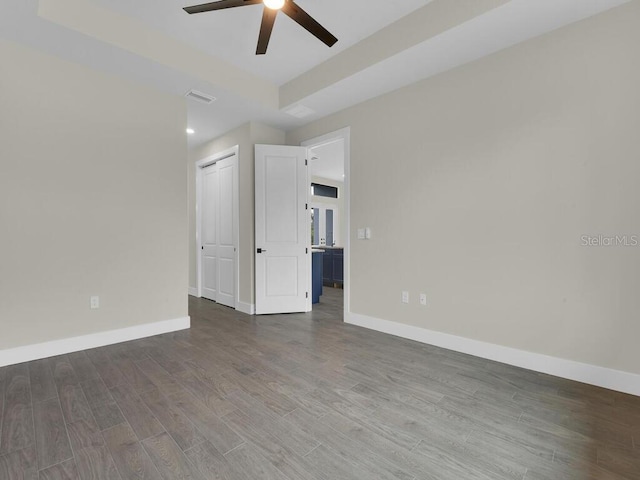 spare room featuring visible vents, baseboards, a ceiling fan, and wood finished floors