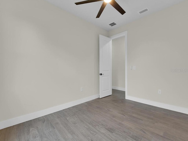 unfurnished room with visible vents, baseboards, a ceiling fan, and wood finished floors