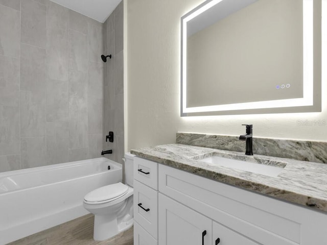 full bath with vanity, toilet, wood finished floors, and shower / bath combination