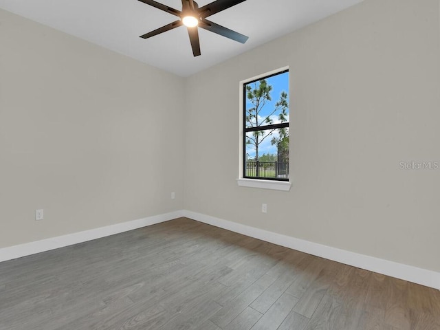 unfurnished room with a ceiling fan, baseboards, and wood finished floors