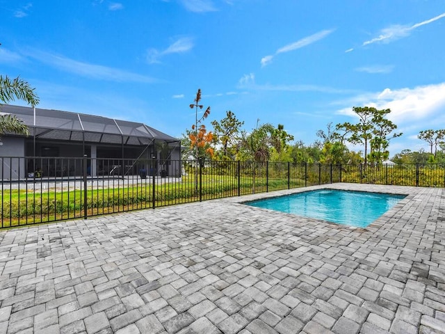 view of swimming pool with glass enclosure, a patio area, a fenced in pool, and fence