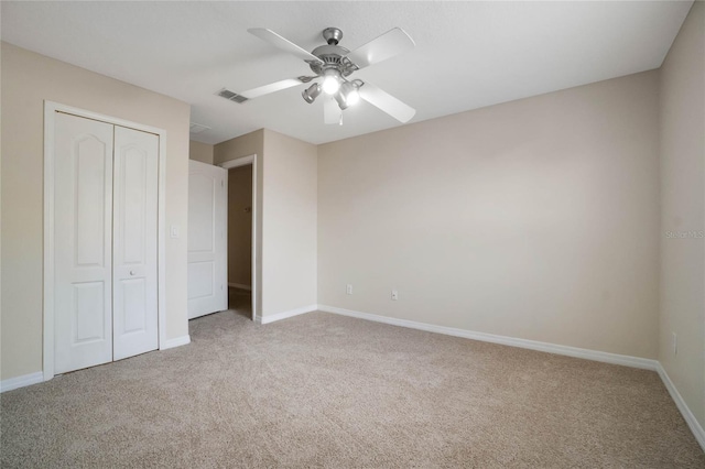 unfurnished bedroom featuring ceiling fan, a closet, and carpet