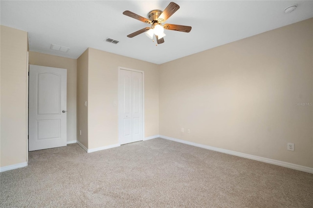 unfurnished bedroom with light carpet, ceiling fan, and a closet