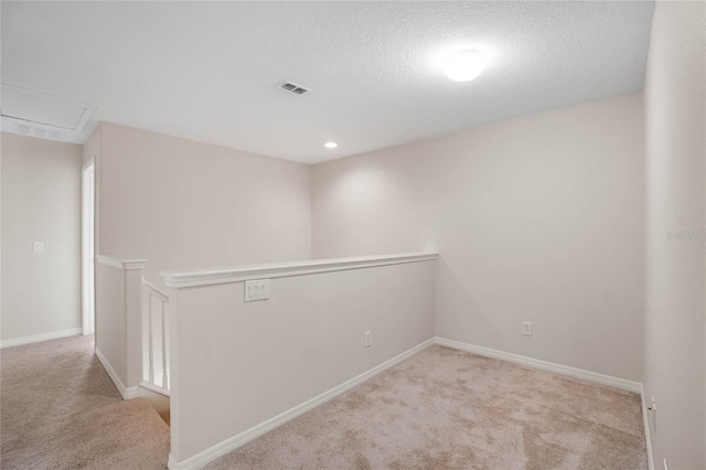 carpeted spare room featuring a textured ceiling