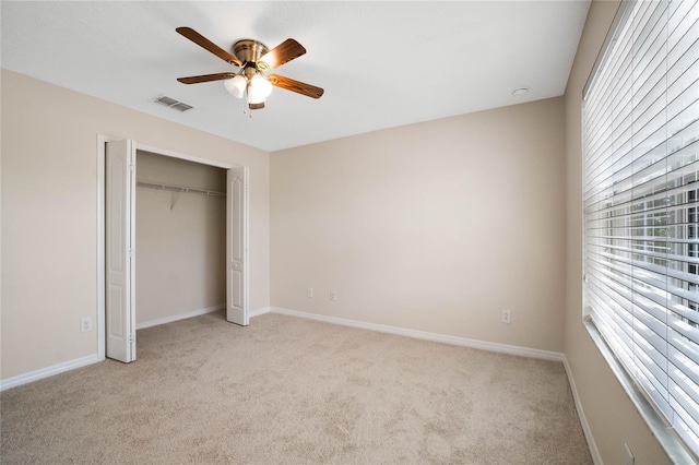 unfurnished bedroom featuring ceiling fan, light colored carpet, and a closet