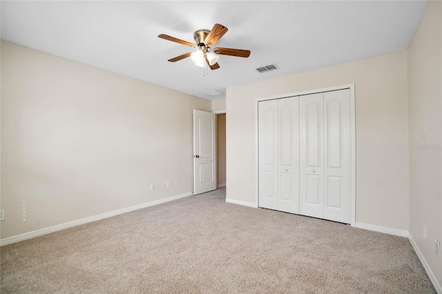 unfurnished bedroom with ceiling fan, a closet, and light carpet