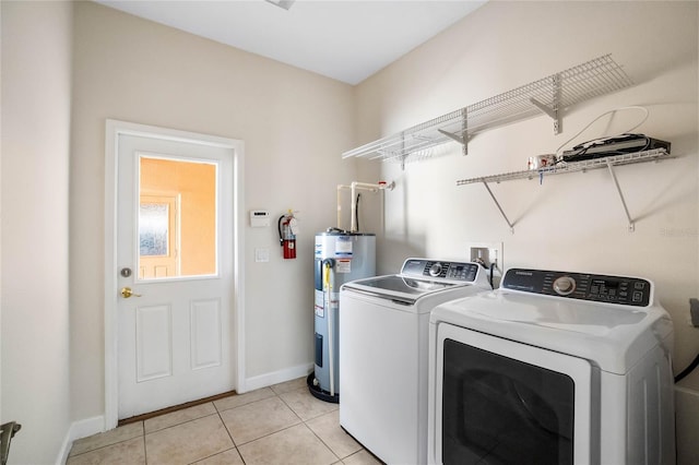 laundry area featuring washer and clothes dryer, electric water heater, and light tile patterned flooring