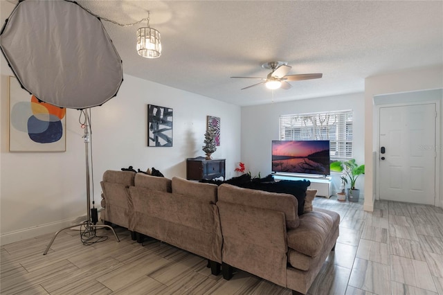 living room with a textured ceiling and ceiling fan with notable chandelier