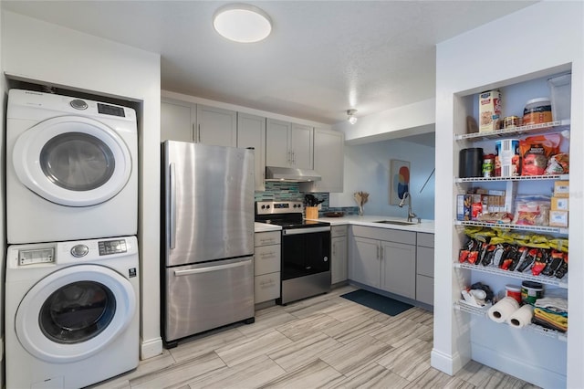 laundry area with sink and stacked washer and clothes dryer