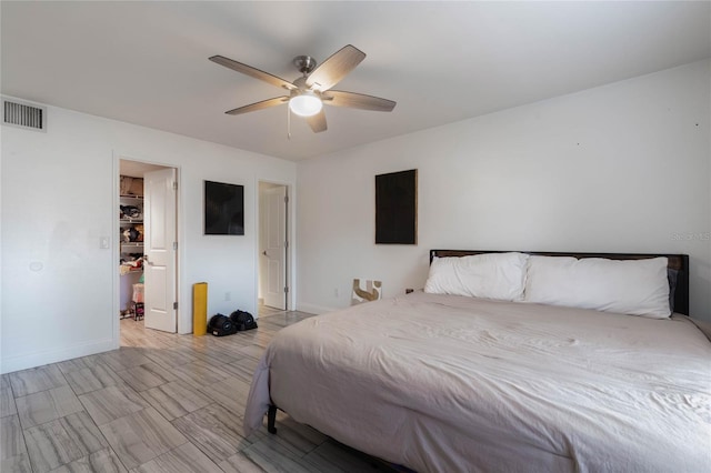 bedroom with a walk in closet and ceiling fan