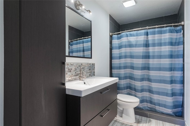 bathroom featuring backsplash, toilet, vanity, and walk in shower