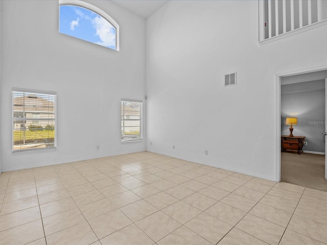 unfurnished living room with a high ceiling and light tile patterned floors