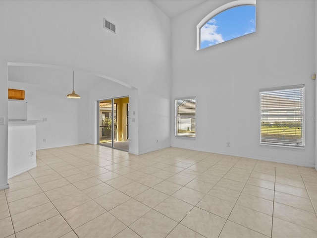 unfurnished living room with a high ceiling and light tile patterned floors