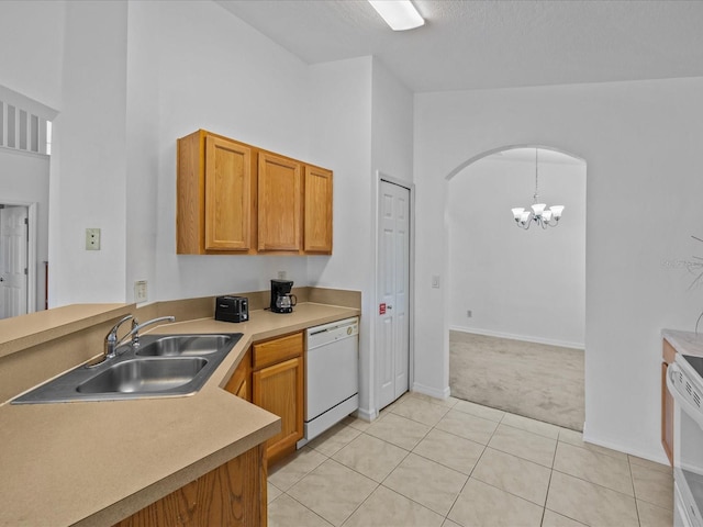 kitchen with sink, decorative light fixtures, white appliances, light tile patterned floors, and a chandelier