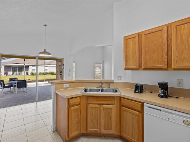 kitchen with kitchen peninsula, dishwasher, hanging light fixtures, light tile patterned floors, and sink