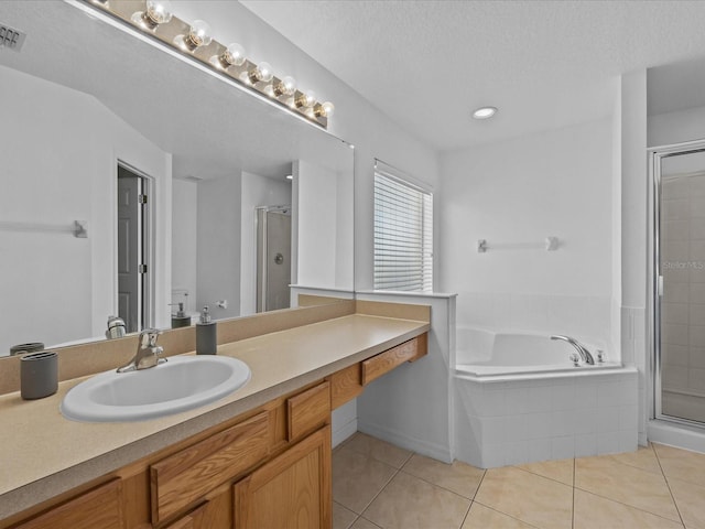 bathroom featuring shower with separate bathtub, tile patterned floors, and a textured ceiling