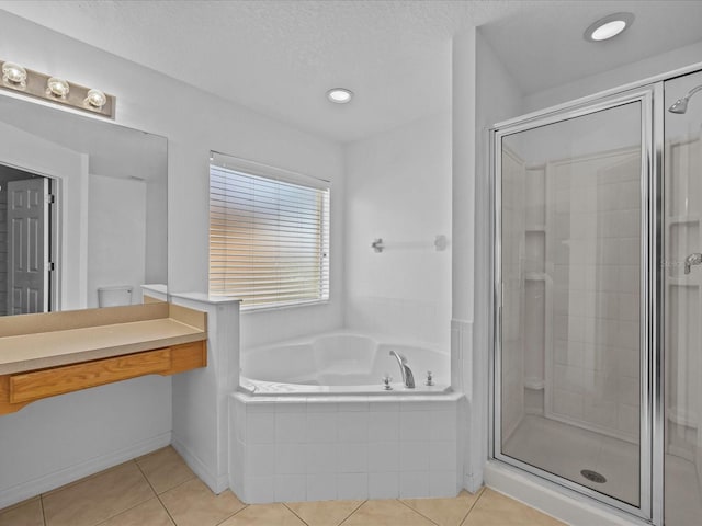 bathroom with a textured ceiling, tile patterned floors, and independent shower and bath