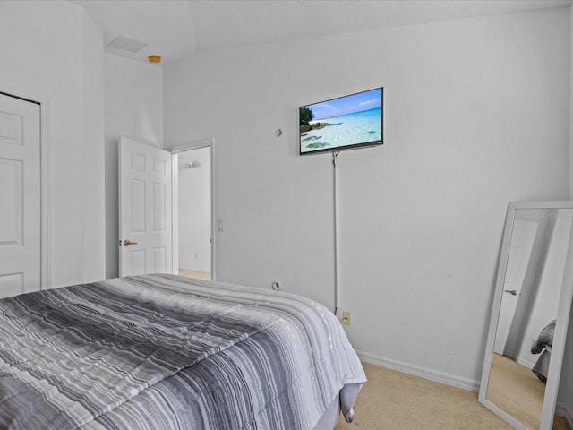 carpeted bedroom with lofted ceiling