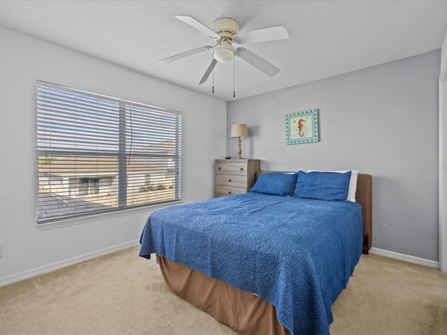 bedroom featuring multiple windows, light carpet, and ceiling fan