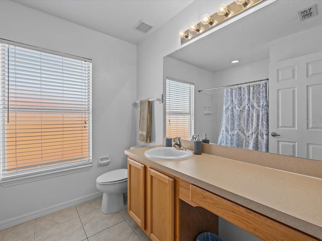 bathroom featuring toilet, vanity, tile patterned floors, and walk in shower