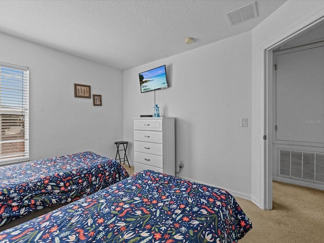 carpeted bedroom featuring a textured ceiling