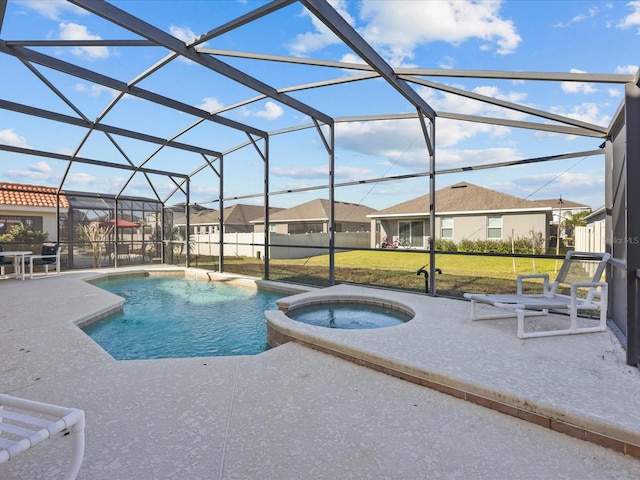 view of pool featuring a patio, glass enclosure, an in ground hot tub, and a yard