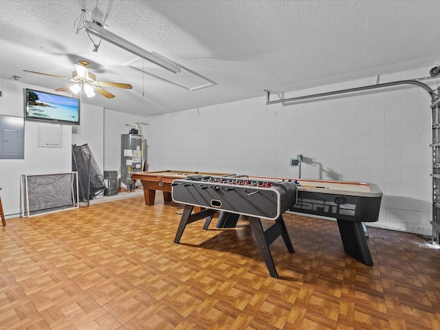 game room with a textured ceiling, ceiling fan, gas water heater, and electric panel