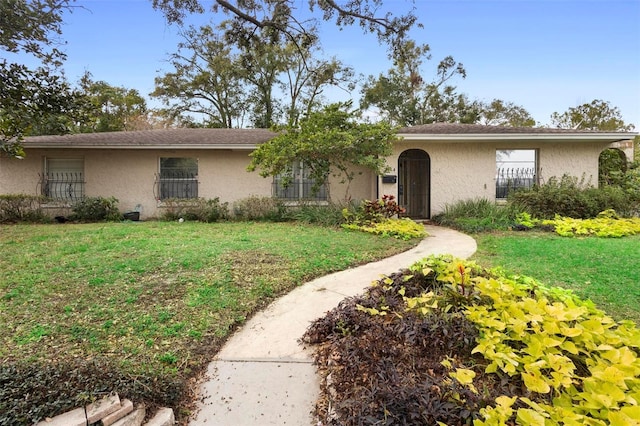 ranch-style home featuring a front yard